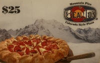 a pizza on a plate with mountains in the background